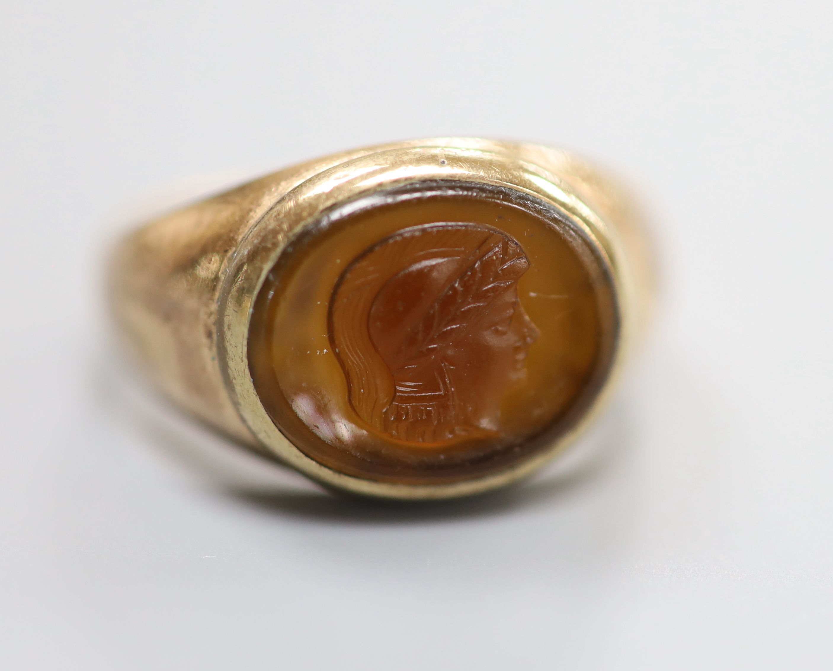 A yellow metal and oval cameo hardstone ring, carved with the head of a classical figure to sinister, size I/J, gross 2.9 grams.